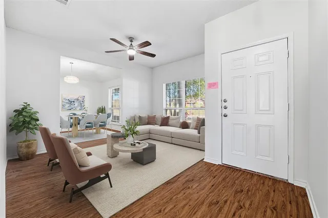 a living room with furniture and a wooden floor
