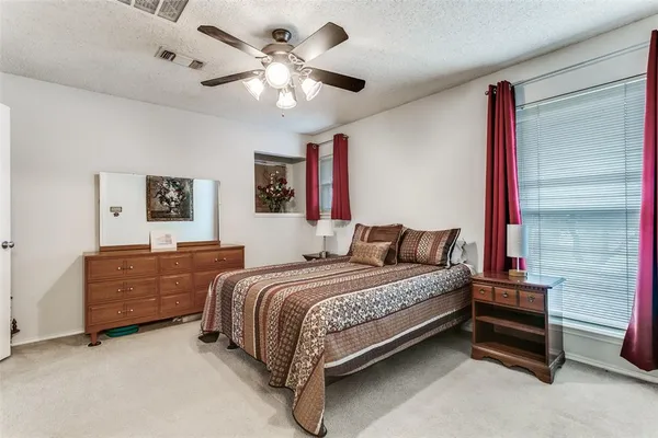 a bedroom with a bed chandelier and a window