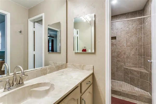 a bathroom with a granite countertop sink and a mirror