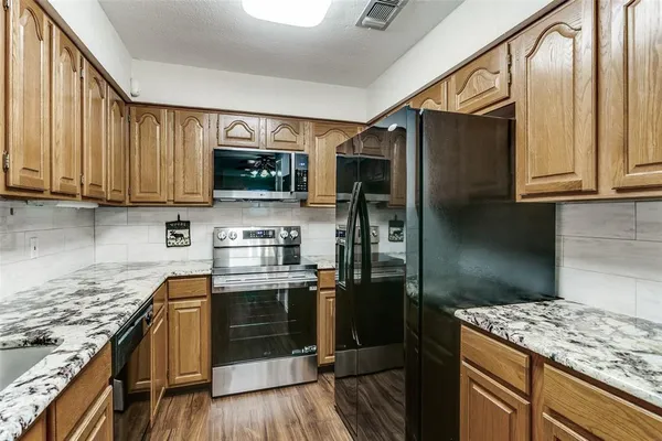 a kitchen with stainless steel appliances granite countertop a stove a refrigerator and a microwave