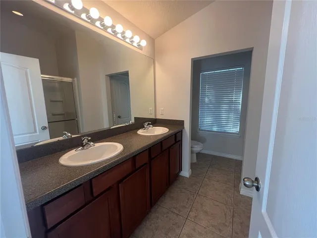 a bathroom with a double vanity sink and a mirror