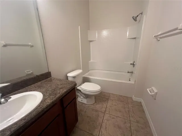a bathroom with a granite countertop sink toilet a mirror and shower