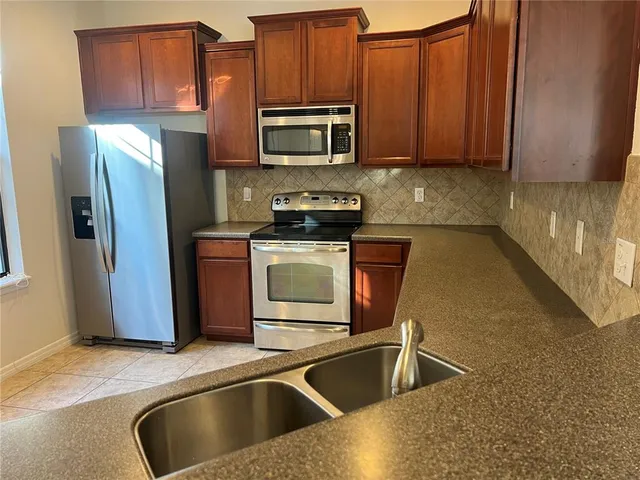 a kitchen with granite countertop a sink and stainless steel appliances