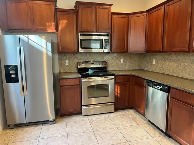 a kitchen with stainless steel appliances granite countertop a stove top oven microwave and cabinets