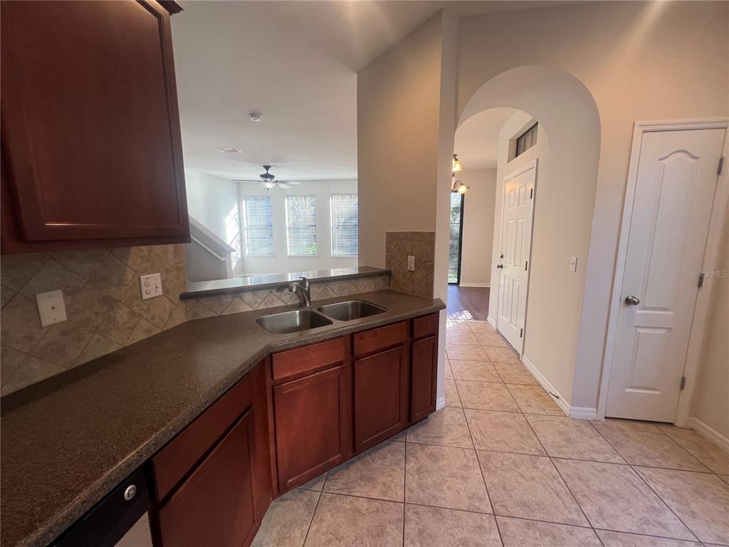 5706 Kingletsound Lithia, FL 33547 - Photo 6 of 16 a large kitchen with a sink and dishwasher a stove top oven with wooden floor