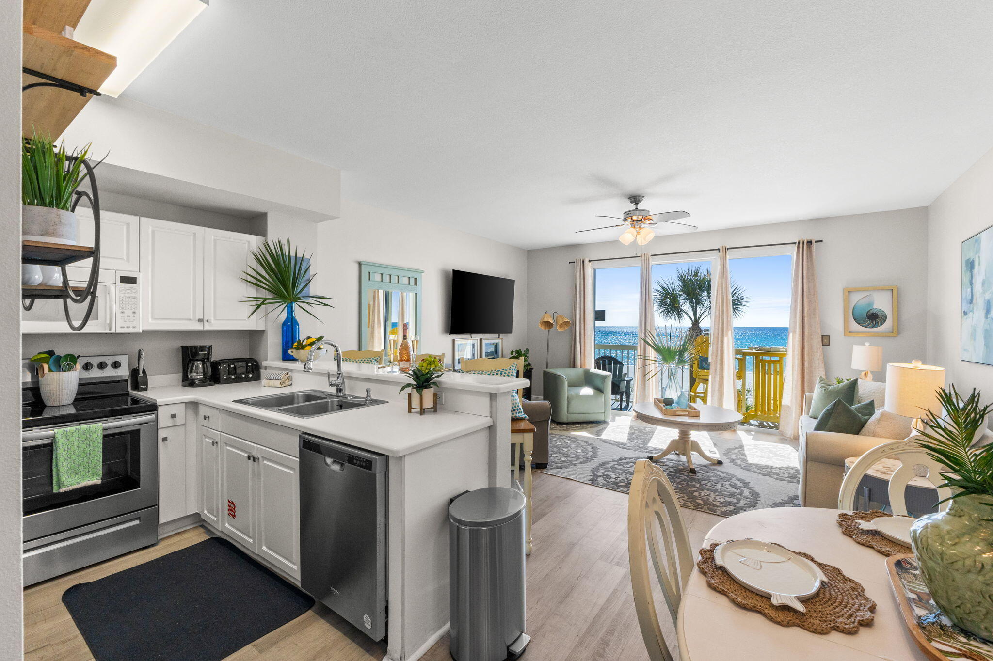 17757 Front Beach Road, Unit 104 Panama City Beach, FL 32413 - Photo 14 of 40 a kitchen with a stove top oven a sink a dining table and chairs