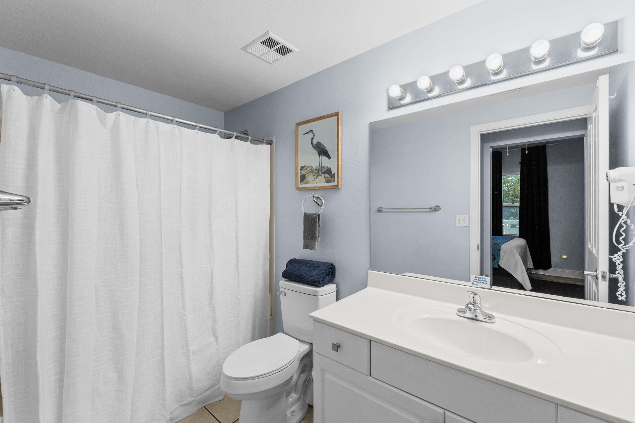 17757 Front Beach Road, Unit 104 Panama City Beach, FL 32413 - Photo 23 of 40 a bathroom with a sink vanity mirror and toilet