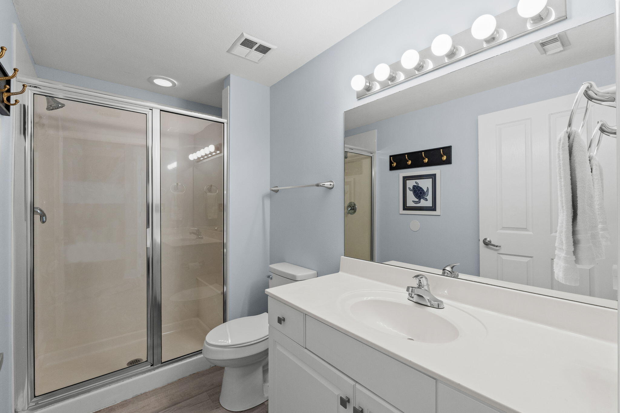 17757 Front Beach Road, Unit 104 Panama City Beach, FL 32413 - Photo 26 of 40 a bathroom with a toilet a sink a shower and a mirror