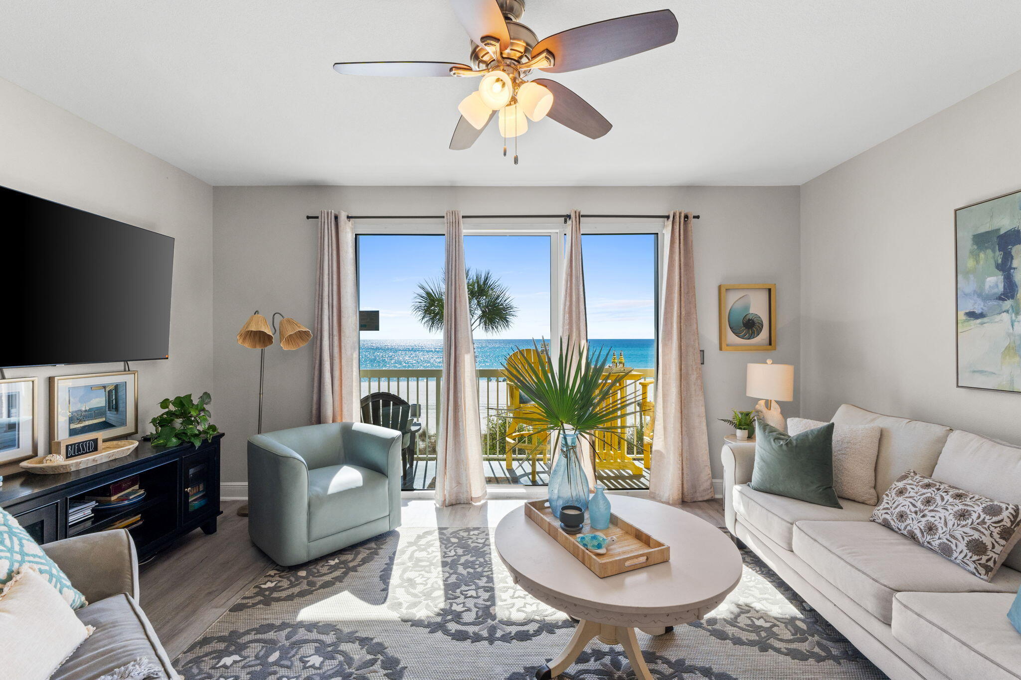 17757 Front Beach Road, Unit 104 Panama City Beach, FL 32413 - Photo 9 of 40 a living room with furniture a flat screen tv and a large window