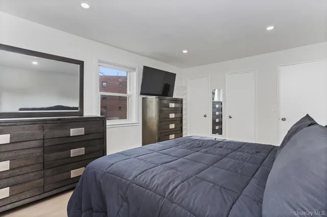 a bedroom with a bed and a flat screen tv