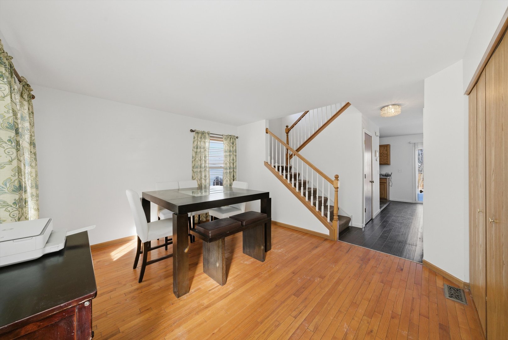 370 Dartmoor Avenue Romeoville, IL 60446 - Photo 8 of 31 a dining room with wooden floor a chandelier a wooden table and chairs