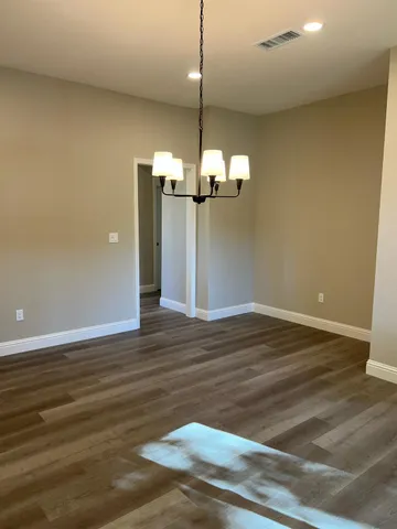 a view of a room with wooden floor and chandelier
