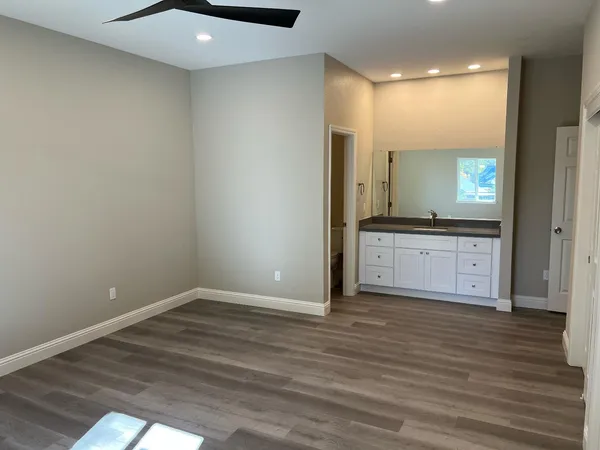 a view of a kitchen with wooden floor and cabinets
