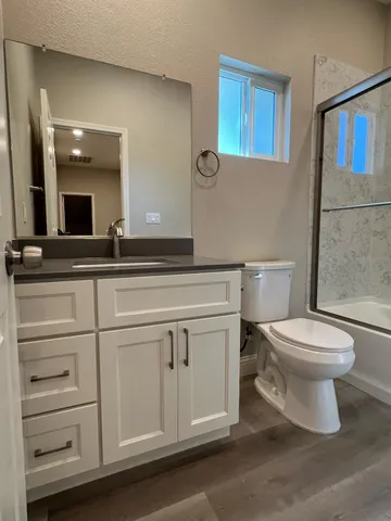 a bathroom with a toilet a sink and mirror