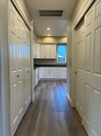 a view of a hallway with wooden floor