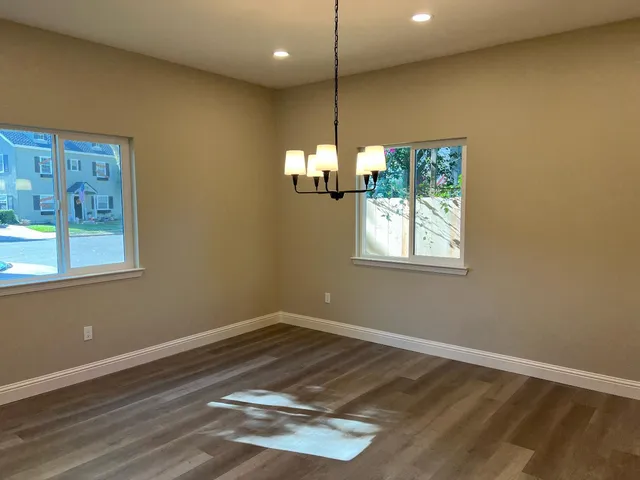 a view of empty room with window and wooden floor