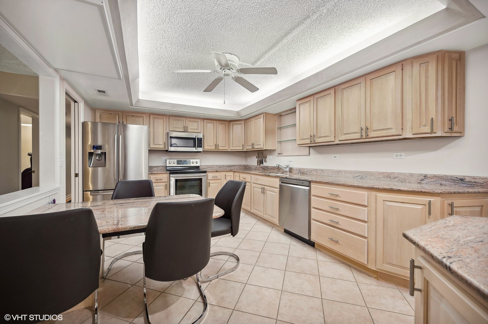 710 Waukegan Road, Unit 303 Glenview, IL 60025 - Photo 5 of 15 a kitchen with stainless steel appliances granite countertop a stove a sink dishwasher and a refrigerator with wooden cabinets