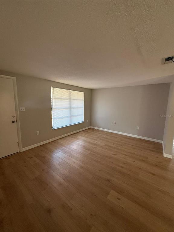 7808 Talisman Drive Port Richey, FL 34668 - Photo 11 of 20 an empty room with wooden floor and windows