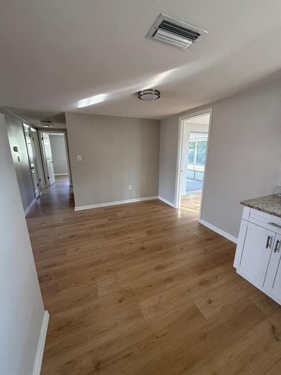 7808 Talisman Drive Port Richey, FL 34668 - Photo 15 of 20 an empty room with wooden floor and windows