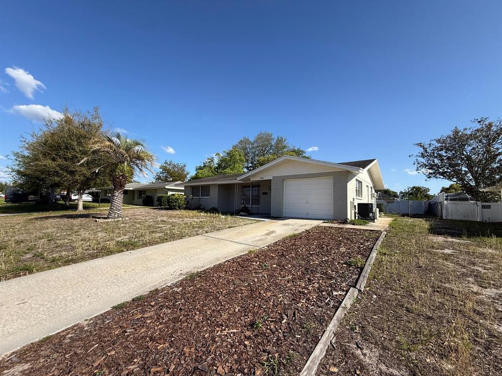 7808 Talisman Drive Port Richey, FL 34668 - Photo 2 of 20 a front view of a house with a yard and garage