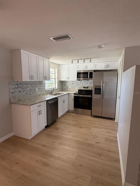 7808 Talisman Drive Port Richey, FL 34668 - Photo 5 of 20 a kitchen with stainless steel appliances granite countertop a stove sink and refrigerator