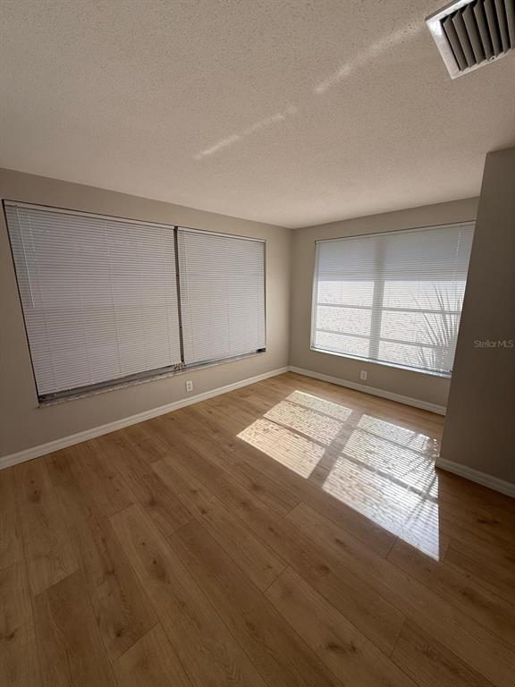 7808 Talisman Drive Port Richey, FL 34668 - Photo 8 of 20 an empty room with wooden floor and windows