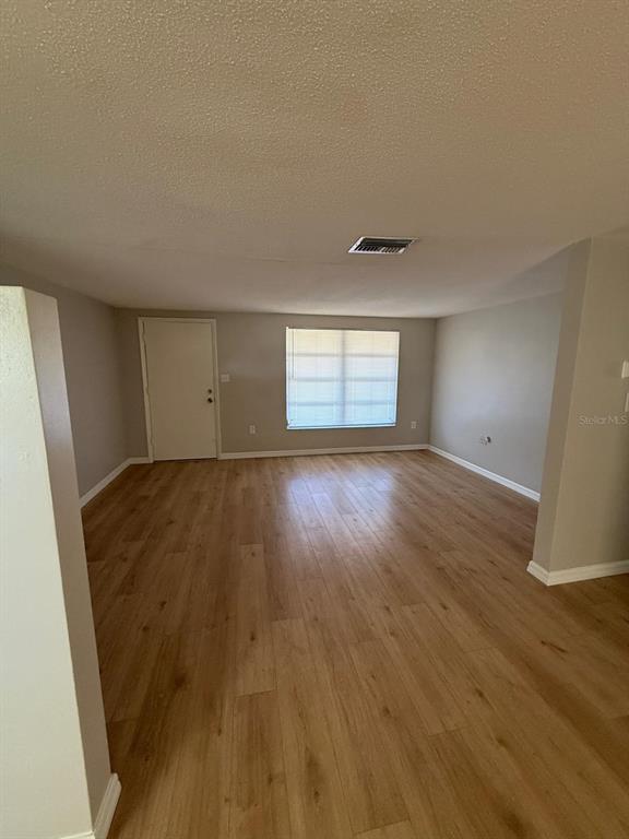 7808 Talisman Drive Port Richey, FL 34668 - Photo 9 of 20 an empty room with wooden floor and windows