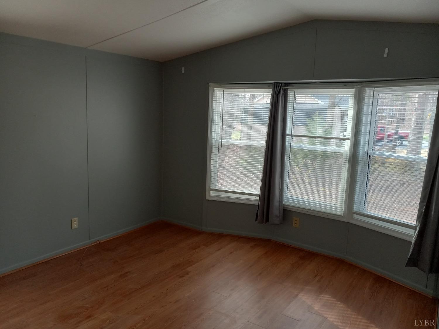 468 Hawkins Road Evington, VA 24550 - Photo 15 of 31 an empty room with wooden floor and windows