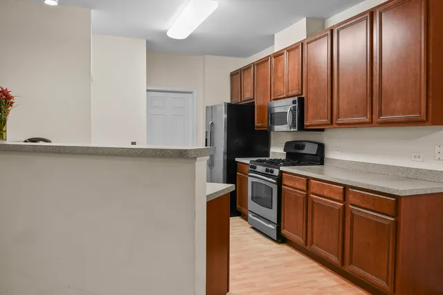 a kitchen with stainless steel appliances granite countertop a refrigerator a stove top oven a sink and dishwasher