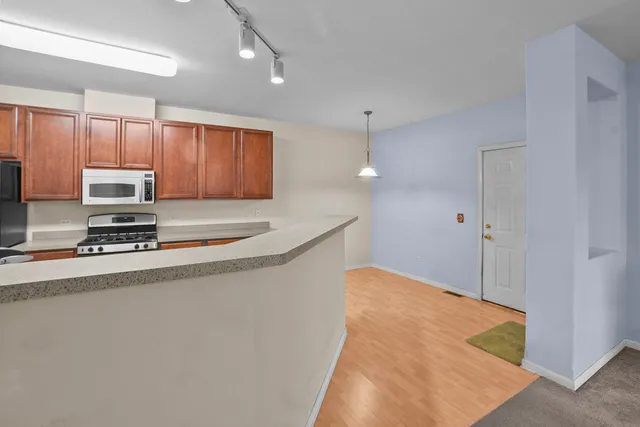 a kitchen with stainless steel appliances a refrigerator a stove a sink cabinets and a refrigerator