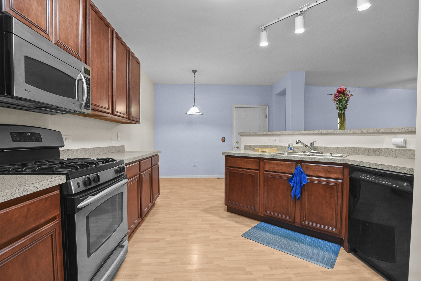 8815 Concord Lane, Unit G Justice, IL 60458 - Photo 13 of 27 a kitchen with stainless steel appliances granite countertop a stove a sink and a microwave