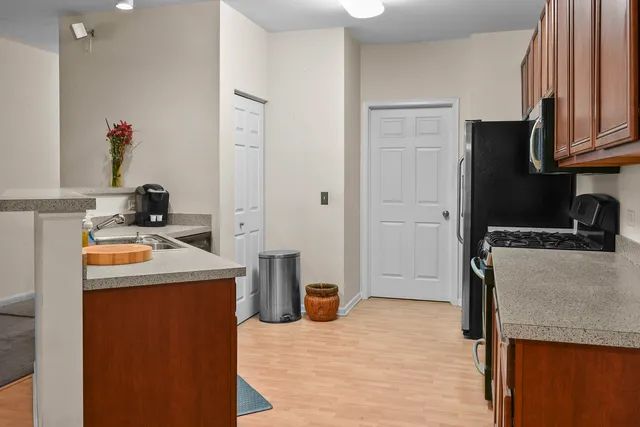 a kitchen with stainless steel appliances granite countertop a refrigerator and a stove