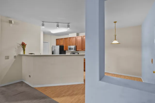a kitchen view of a refrigerator and window