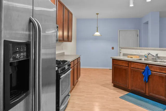 a kitchen with stainless steel appliances granite countertop a refrigerator and a stove