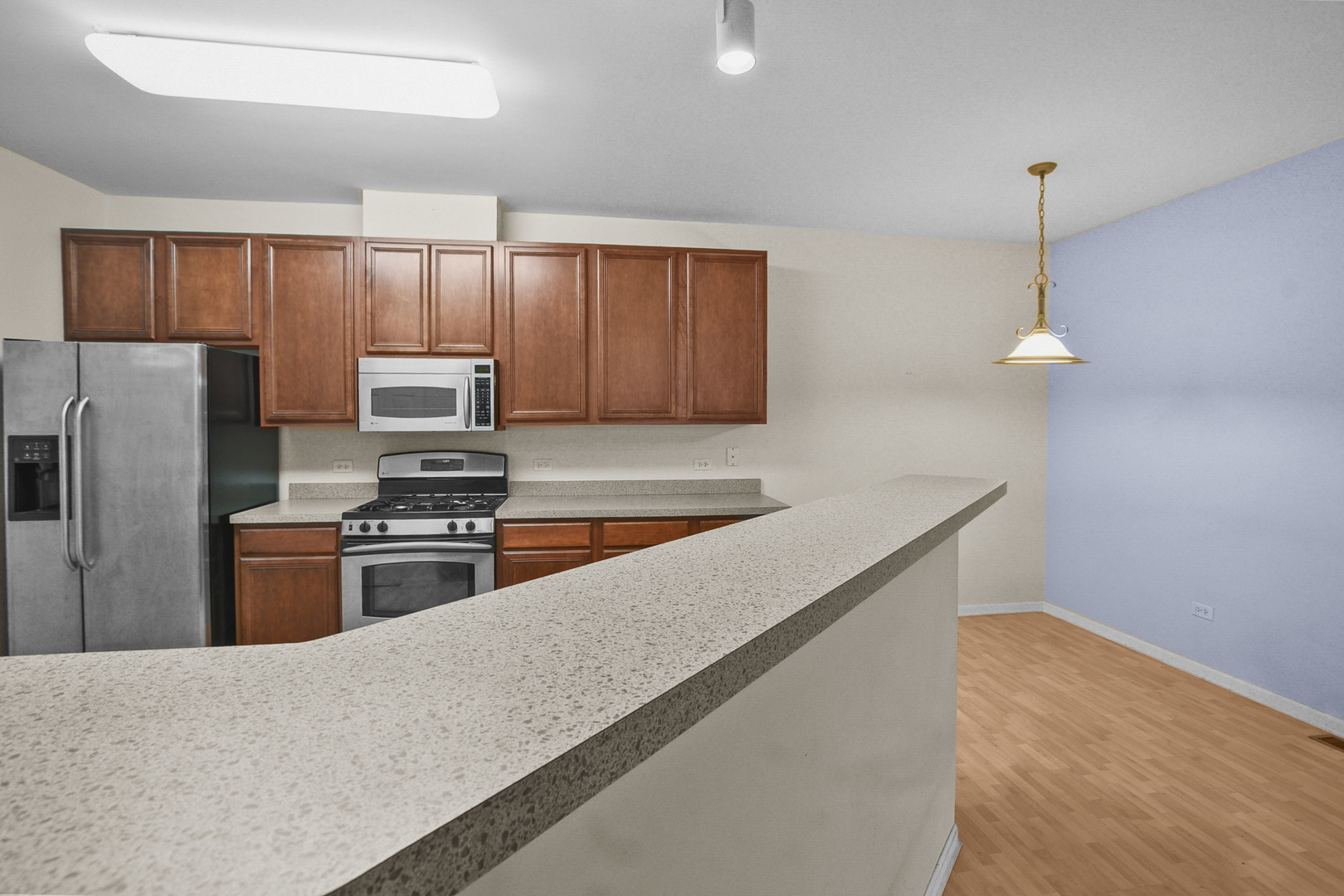 8815 Concord Lane, Unit G Justice, IL 60458 - Photo 10 of 27 a kitchen with stainless steel appliances a refrigerator a stove a sink cabinets and a center island