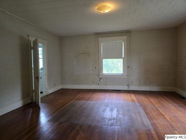 242 Main Street Carthage, IL 62321 - Photo 10 of 28 an empty room with wooden floor and windows