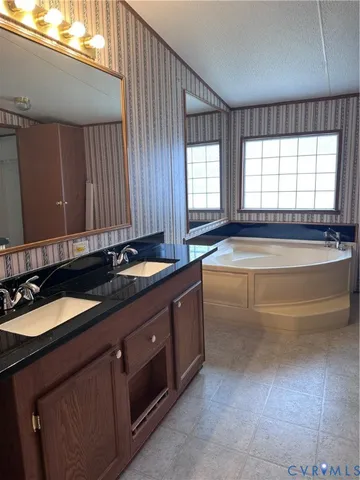 a spacious bathroom with a granite countertop tub sink and mirror