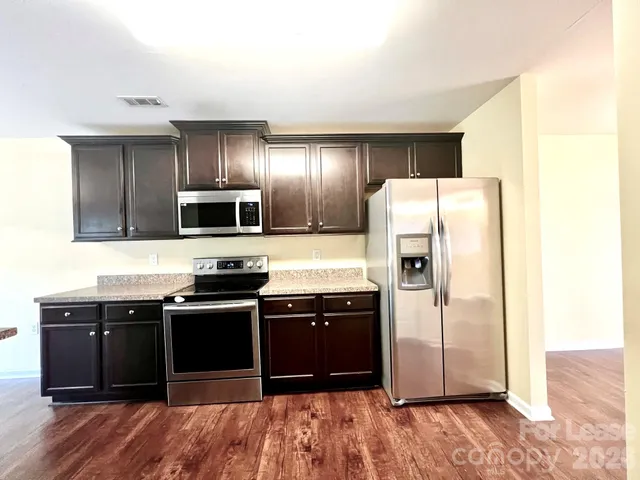 a kitchen with stainless steel appliances granite countertop a refrigerator and a sink