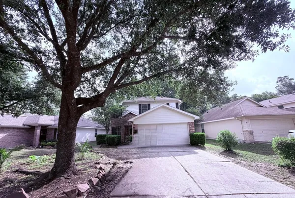 a front view of a house with a yard and tree