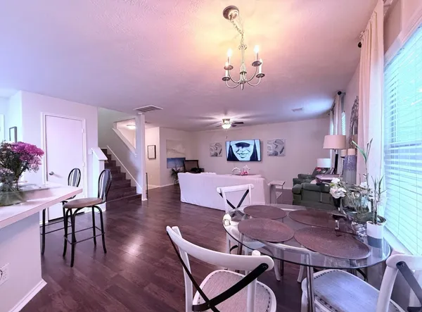 a view of a dining room with furniture wooden floor and chandelier