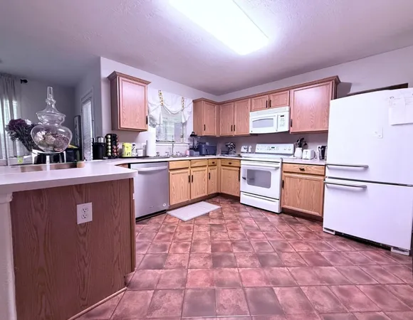 a kitchen with granite countertop a sink stainless steel appliances and cabinets