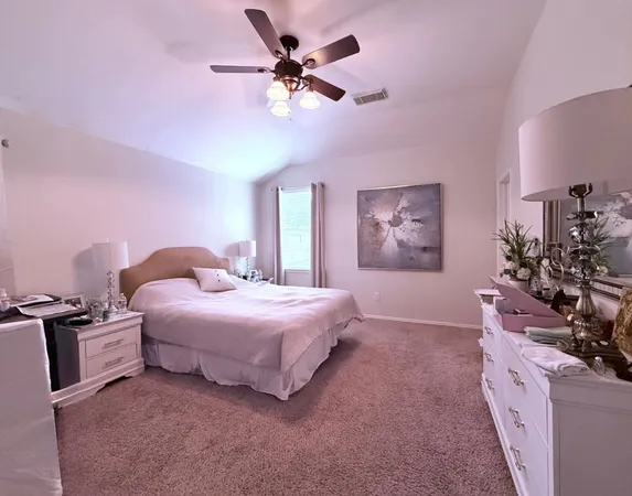 a bedroom with a bed dresser and a chandelier