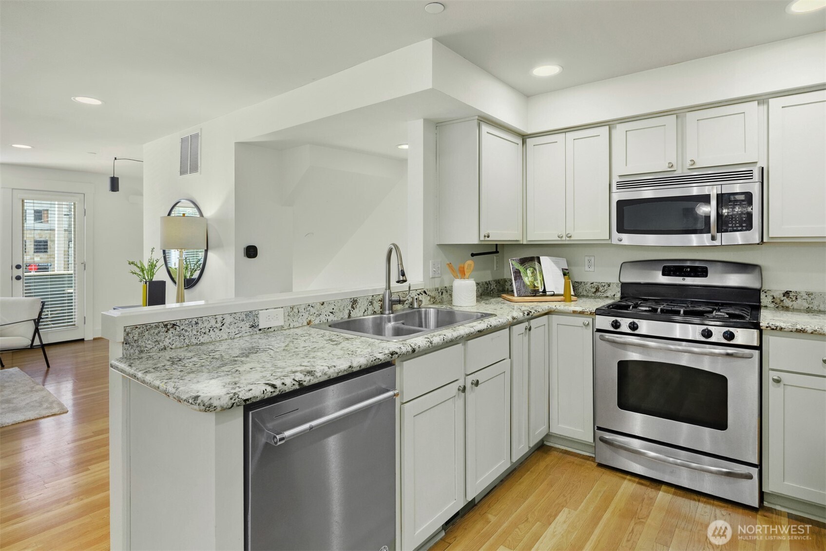5233 Russell Avenue Northwest, Unit A Seattle, WA 98107 - Photo 4 of 29 a kitchen with stainless steel appliances granite countertop a stove sink microwave and cabinets