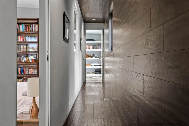 a bedroom with a bed a bookshelf and a flat screen tv