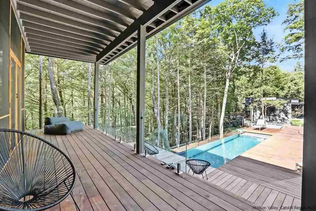 a view of a patio with table and chairs with wooden floor and fence