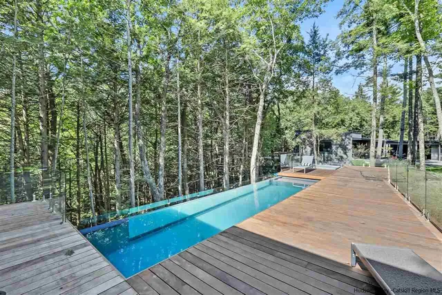 a backyard of a house with table and chairs plants and large tree