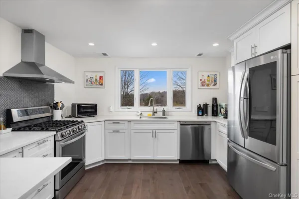 a kitchen with a sink stainless steel appliances a window and a counter top space