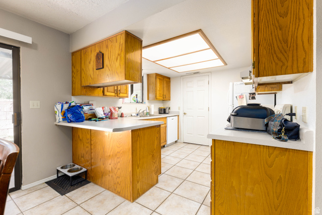 3707 Gates Circle Santa Clara, UT 84765 - Photo 8 of 19 Kitchen with wood finish cabinetry, light tile patterned floors, light countertops, a peninsula, and white appliances