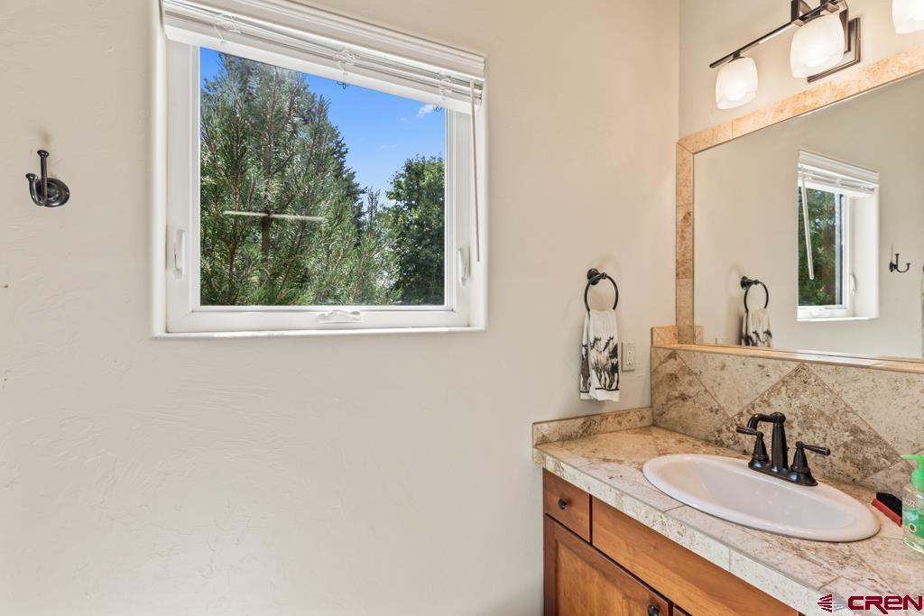 15103 6260th Road Montrose, CO 81403 - Photo 42 of 45 a bathroom with a granite countertop sink a mirror and a window