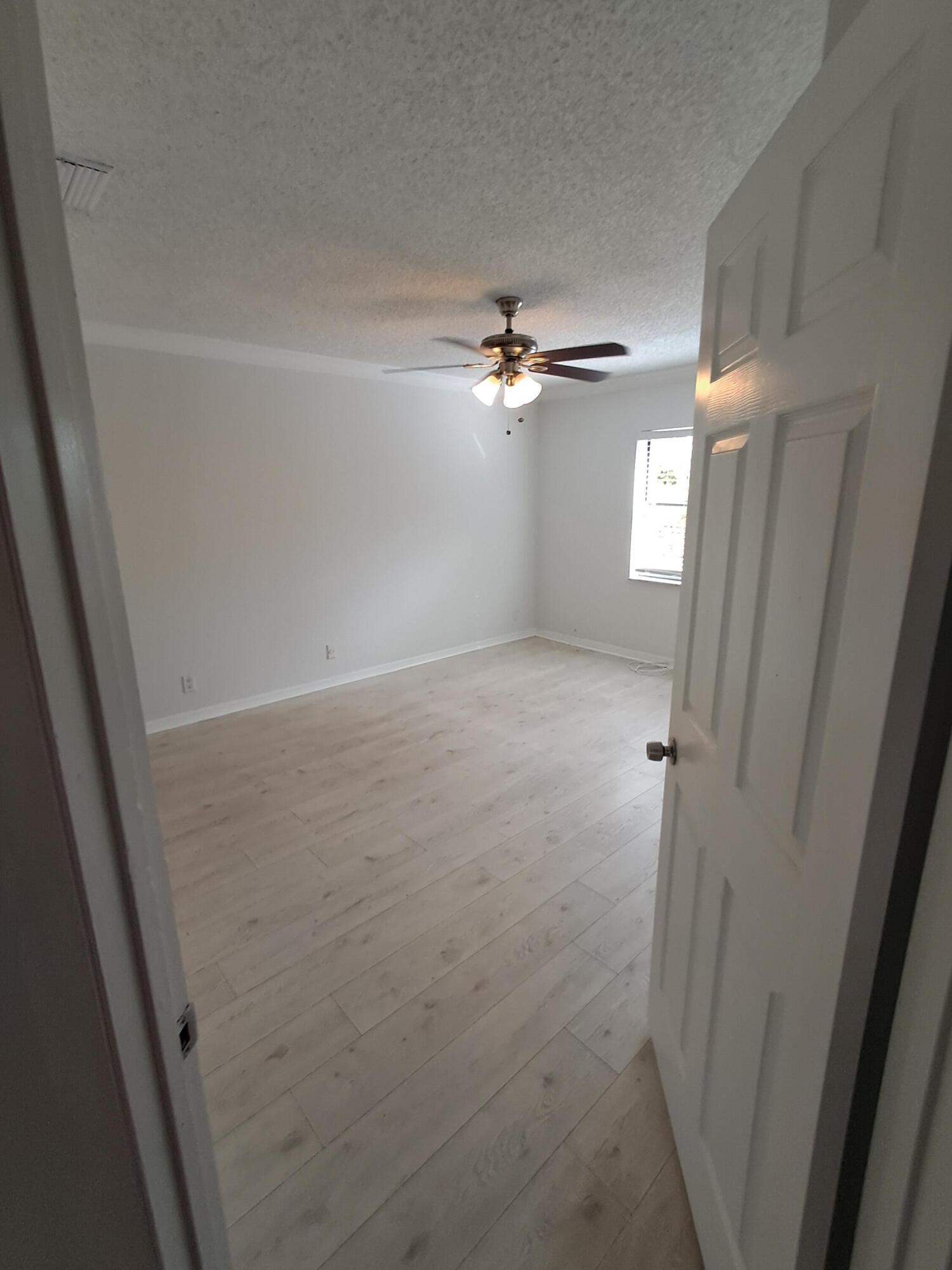 12236 Sag Harbor Court, Unit 4 Wellington, FL 33414 - Photo 5 of 11 an empty room with windows and fan